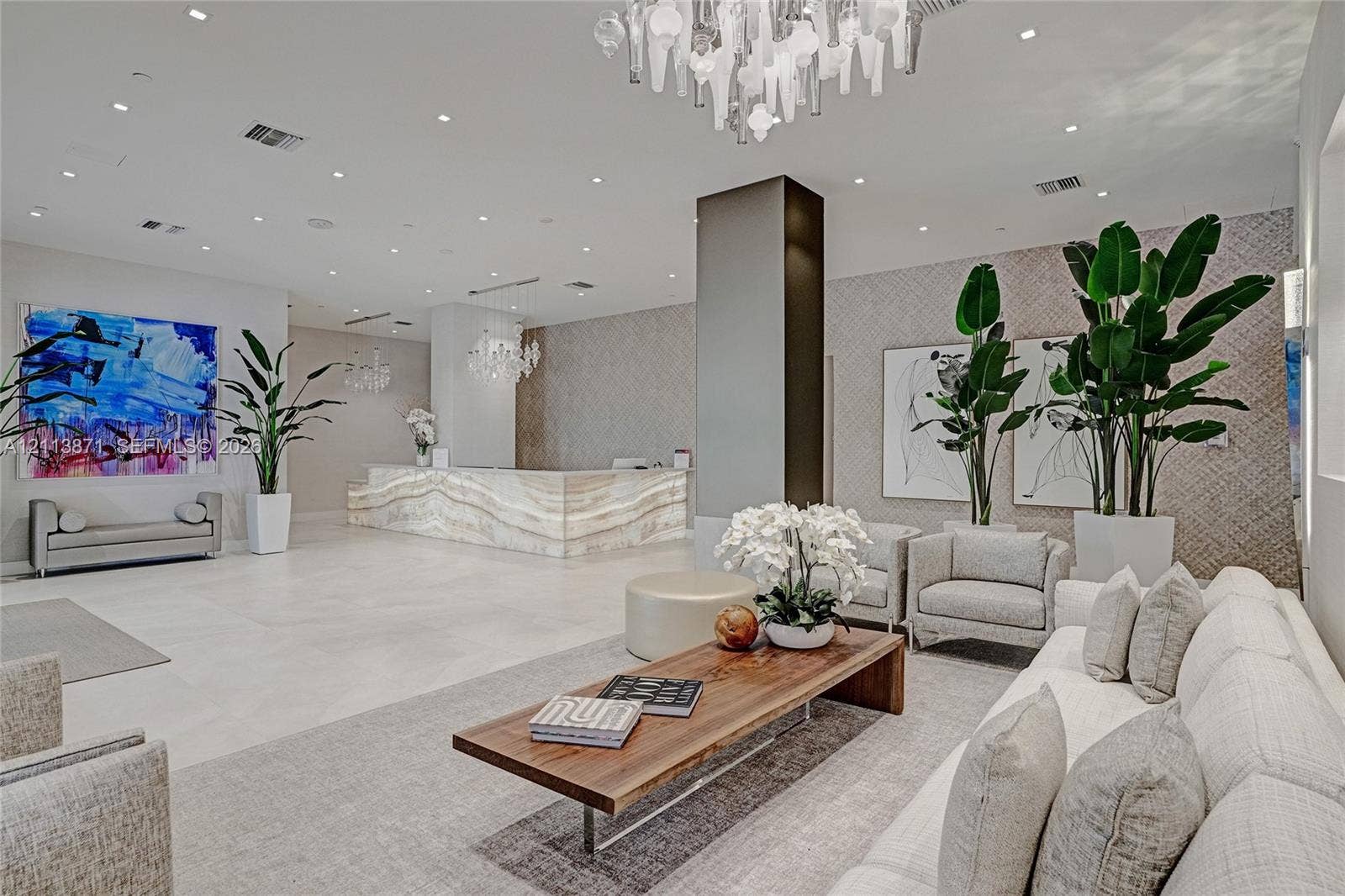 3640 Yacht Club Drive, #1208, Aventura, FL 33180 Lobby featuring a stone-faced reception desk, recessed ceiling lighting, textured wall coverings, and a tiered glass chandelier