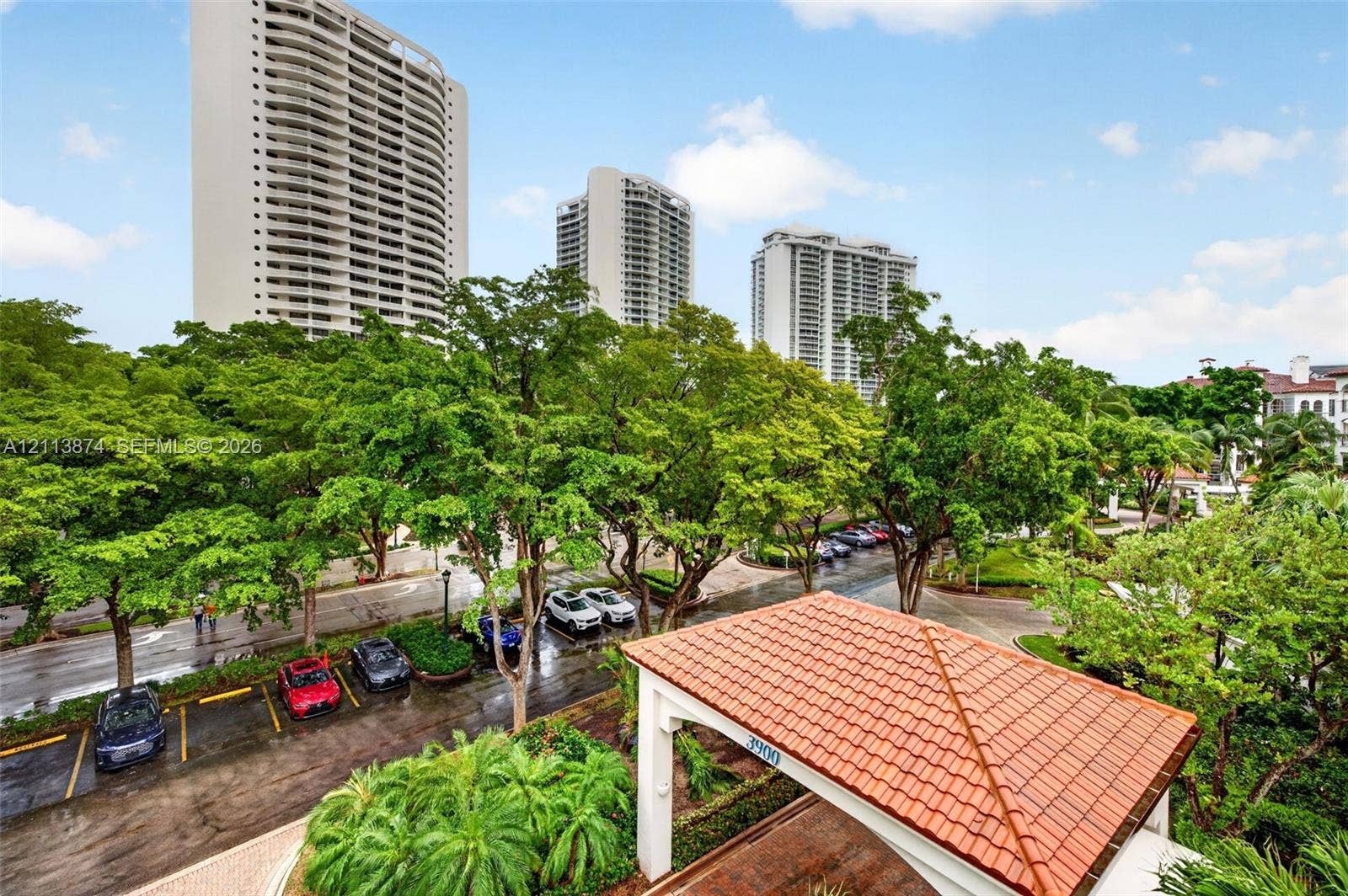 3900 Island Boulevard, #B408, Aventura, Aventura, FL 33160 High-rise residential towers featuring multi-story architectural design, terracotta-tiled porte-cochre, paved driveways, and expansive mature landscaping