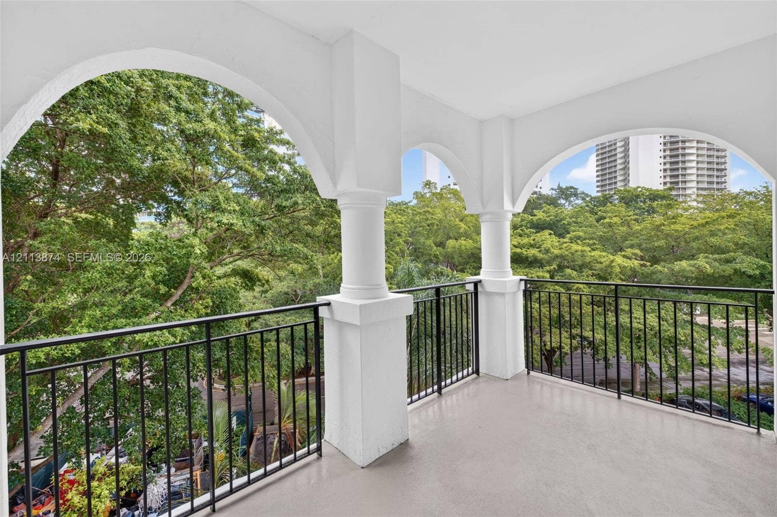 3900 Island Boulevard, #B408, Aventura, Aventura, FL 33160 Covered balcony featuring arched architectural openings, substantial pillars, and a black metal railing
