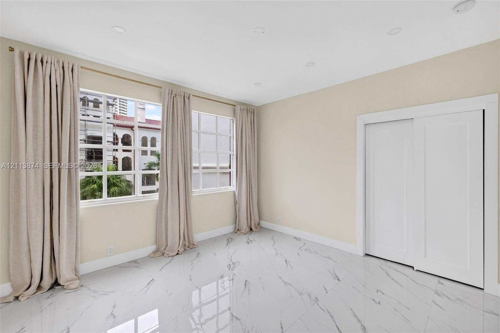 3900 Island Boulevard, #B408, Aventura, Aventura, FL 33160 Polished stone-look tile flooring, grid-patterned windows, and a built-in sliding-door closet, illuminated by recessed lighting