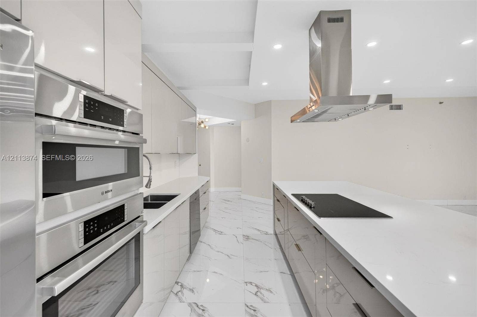 3900 Island Boulevard, #B408, Aventura, Aventura, FL 33160 Modern kitchen featuring high-gloss cabinetry, stone-finish countertops, stainless steel appliances, a built-in cooktop, and an overhead stainless steel range hood