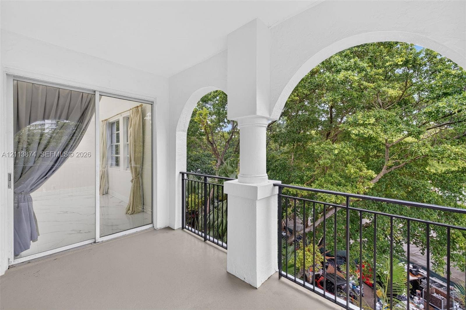 3900 Island Boulevard, #B408, Aventura, Aventura, FL 33160 Covered balcony featuring arched architectural openings, decorative columns, and metal railings