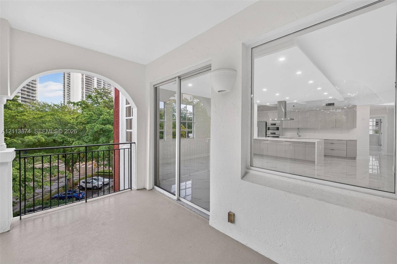3900 Island Boulevard, #B408, Aventura, Aventura, FL 33160 Covered balcony featuring an arched opening, metal railing, and direct glass-panel access to the interior