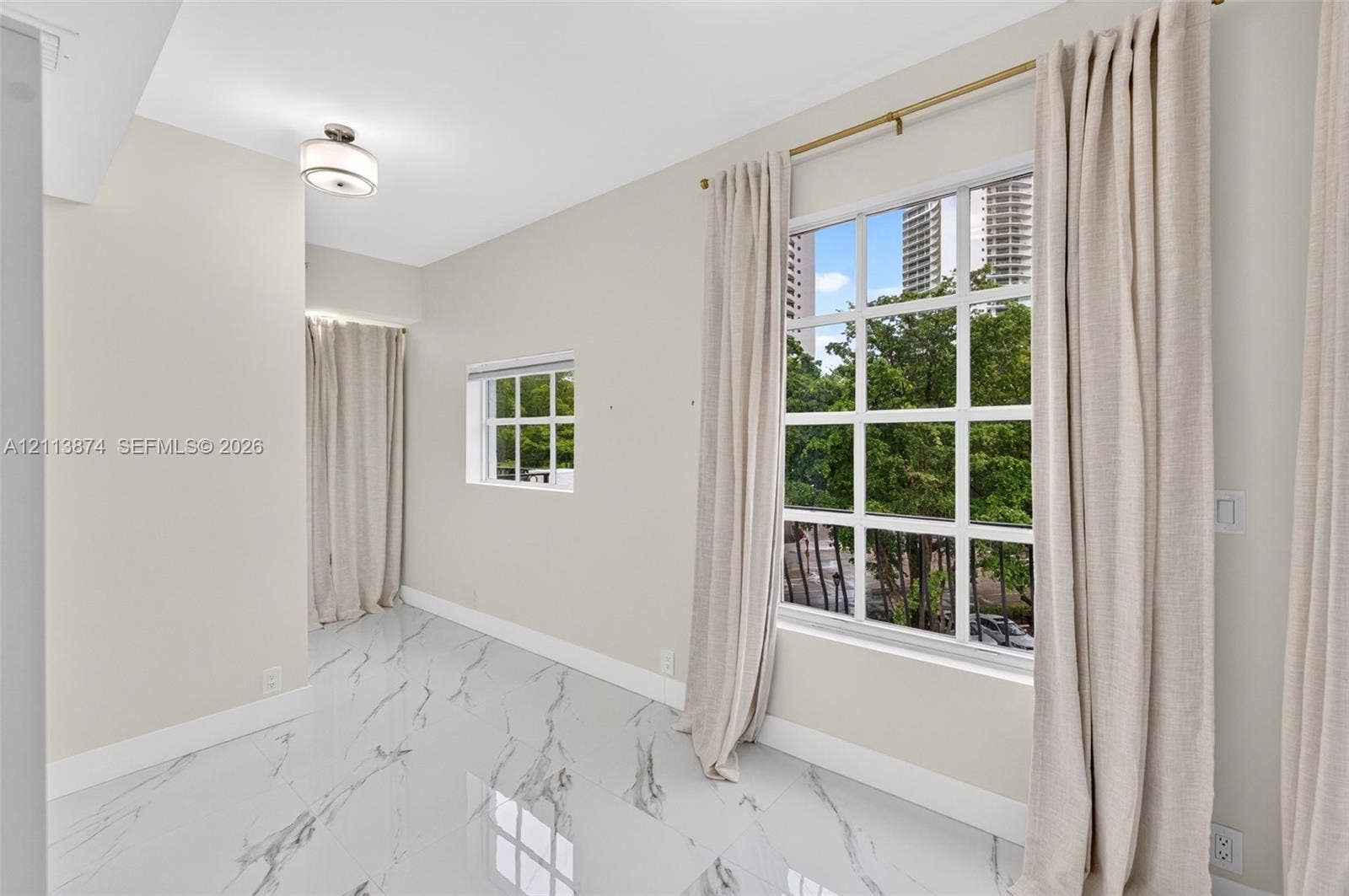 3900 Island Boulevard, #B408, Aventura, Aventura, FL 33160 Large-format tile flooring with marble-style veining, multiple multi-pane windows, and a flush-mount drum ceiling light fixture