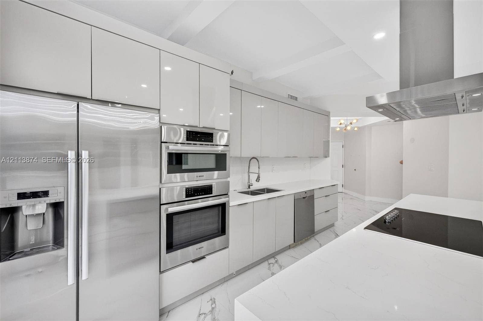 3900 Island Boulevard, #B408, Aventura, Aventura, FL 33160 Modern kitchen featuring high-gloss cabinetry, stainless steel appliances, a stone-finish countertop, a waterfall-edge island, and light-tone flooring