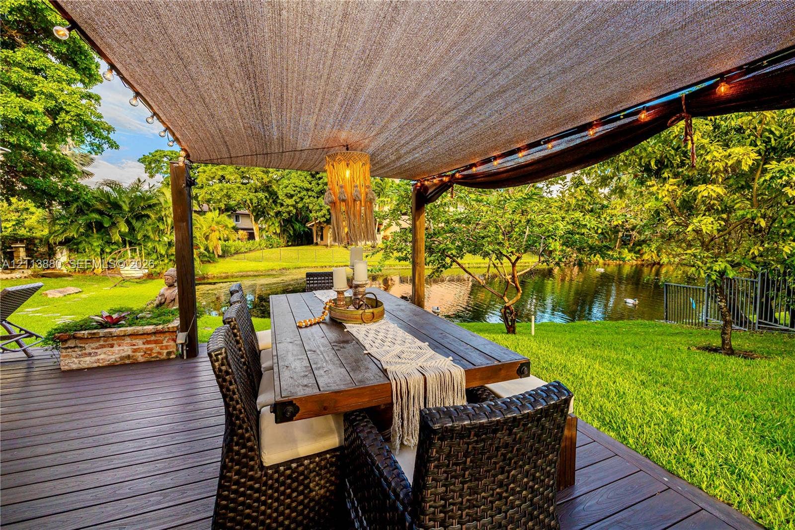 900 Coco Plum Way, Plantation, FL 33324 Outdoor deck featuring wood-finish decking, a fabric sun shade, brick planter, and waterfront exposure