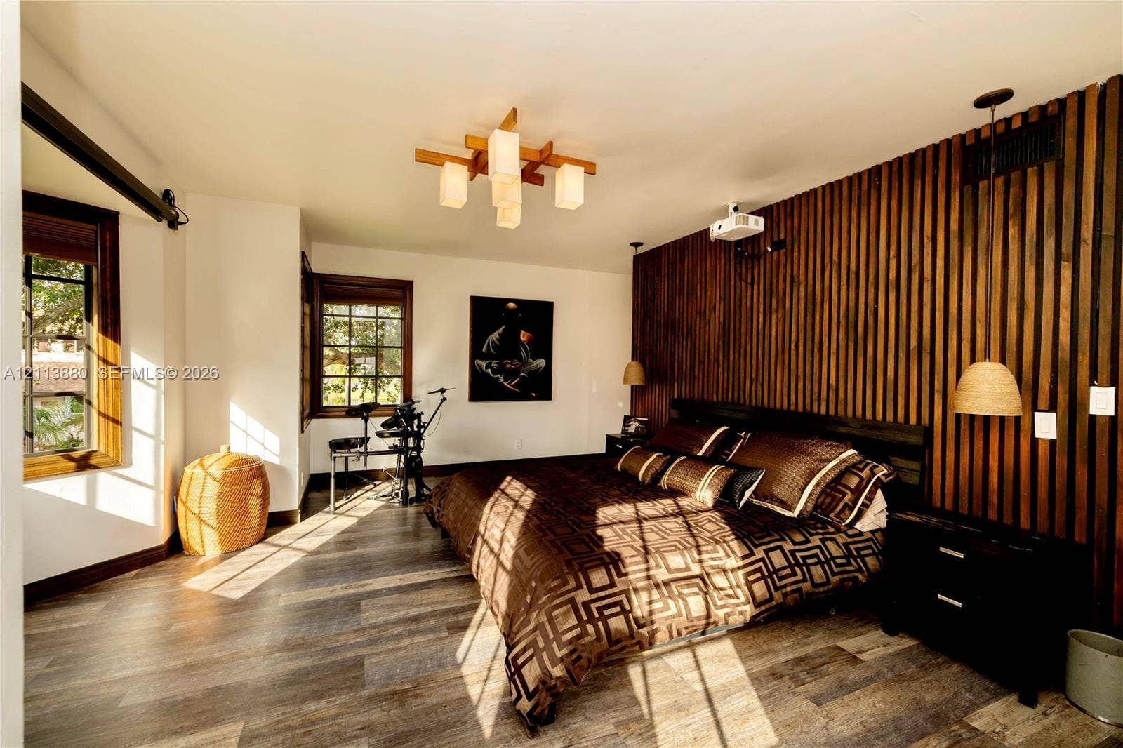 900 Coco Plum Way, Plantation, FL 33324 Interior space featuring a vertical wood-slat accent wall, wood-finish flooring, multi-pane windows with wood trim, a geometric multi-light chandelier, and integrated pendant lighting