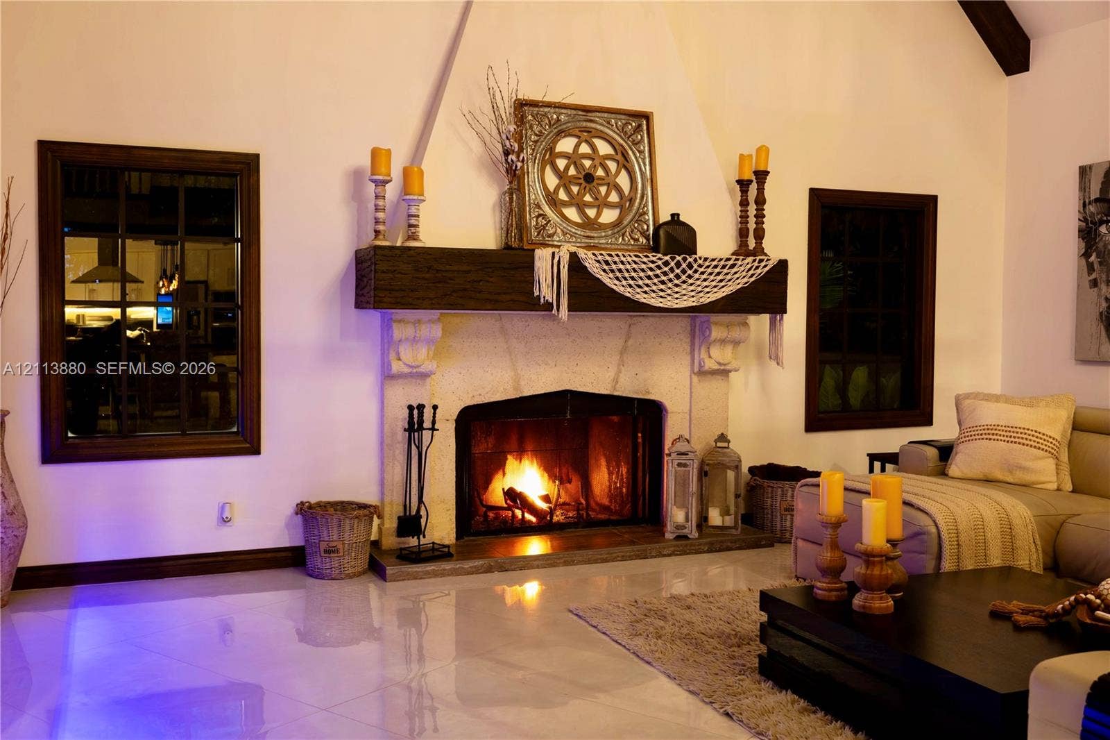 900 Coco Plum Way, Plantation, FL 33324 Floor-to-ceiling fireplace featuring a textured stone surround, heavy timber mantel, and vaulted ceilings, punctuated by dark-frame grid windows