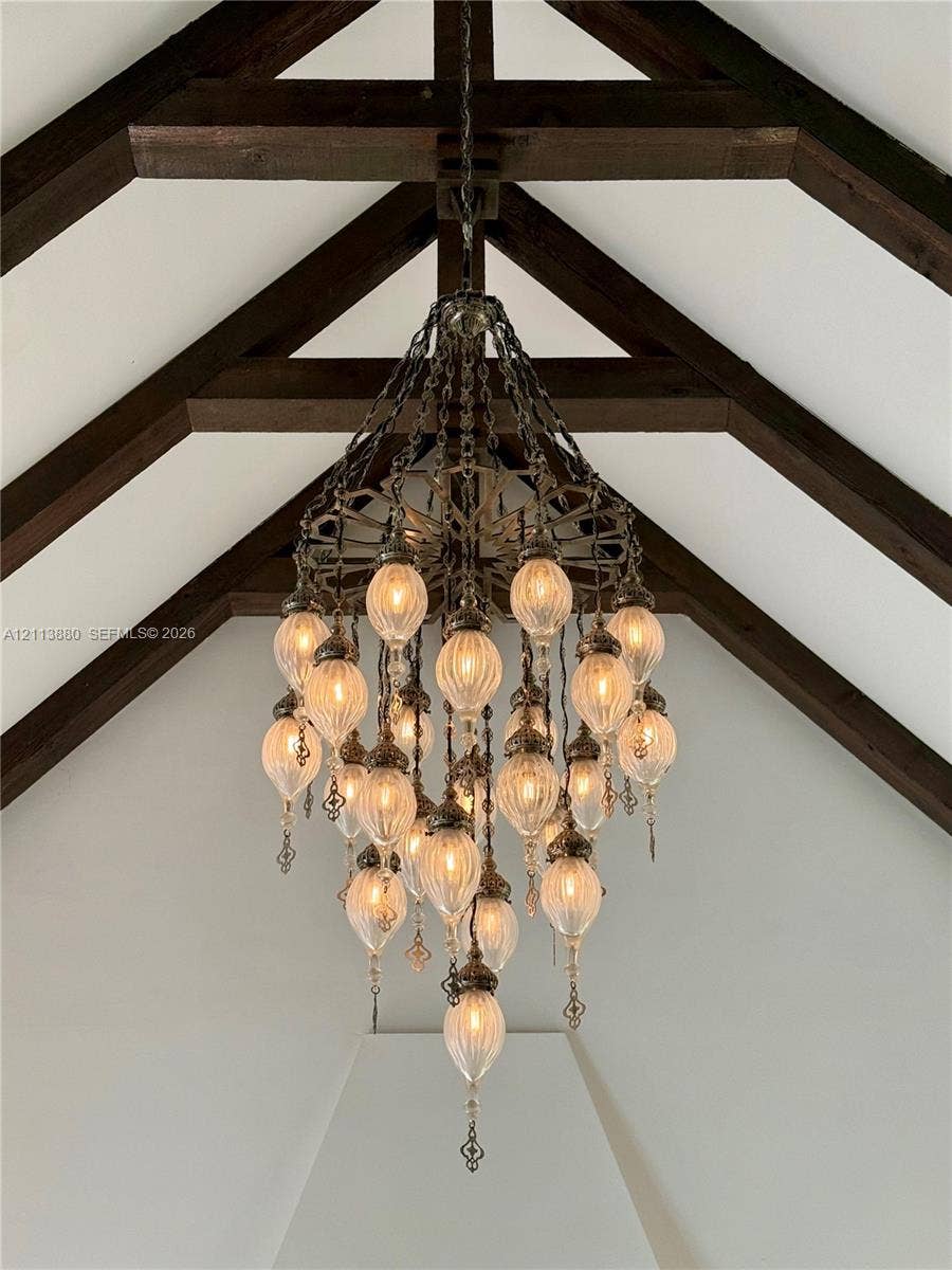 900 Coco Plum Way, Plantation, FL 33324 Vaulted ceiling featuring exposed timber beams and a multi-tiered metal chandelier with scalloped glass fixtures