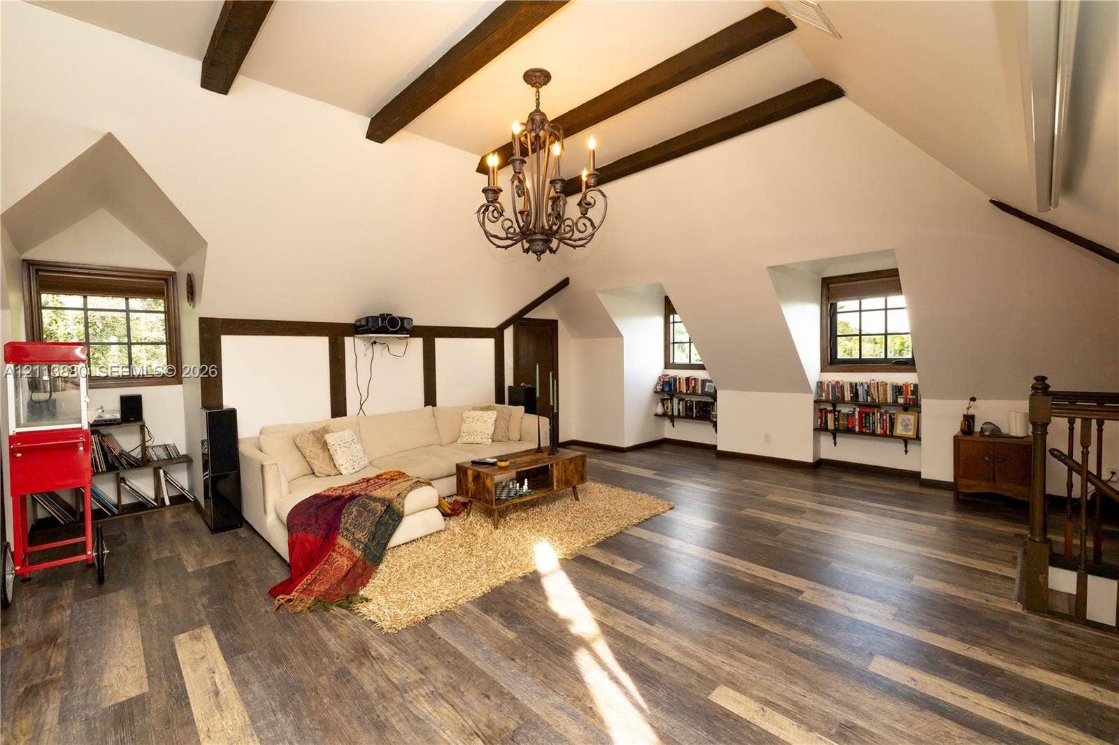 900 Coco Plum Way, Plantation, FL 33324 Vaulted ceiling featuring exposed wood beams, wood-finish flooring, multi-arm metal chandelier, built-in shelving, and dormer windows