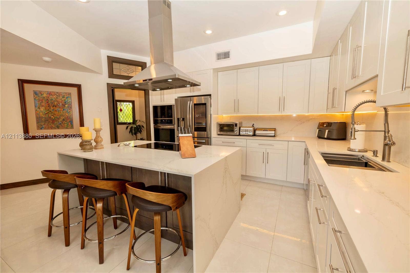 900 Coco Plum Way, Plantation, FL 33324 Kitchen featuring white flat-panel cabinetry, a central island with quartz surfacing, stainless steel appliances, a stainless steel range hood, and tile flooring