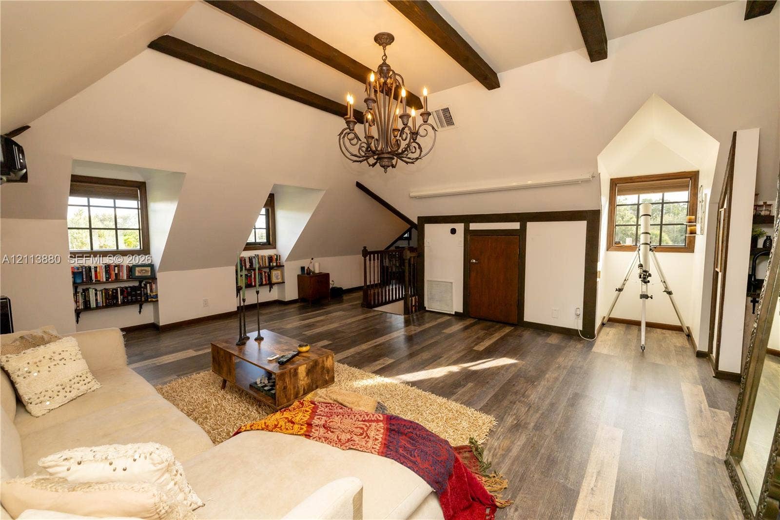 900 Coco Plum Way, Plantation, FL 33324 Vaulted ceiling with exposed wood beams, wood-finish flooring, custom built-in shelving, dormer windows, and a multi-arm chandelier