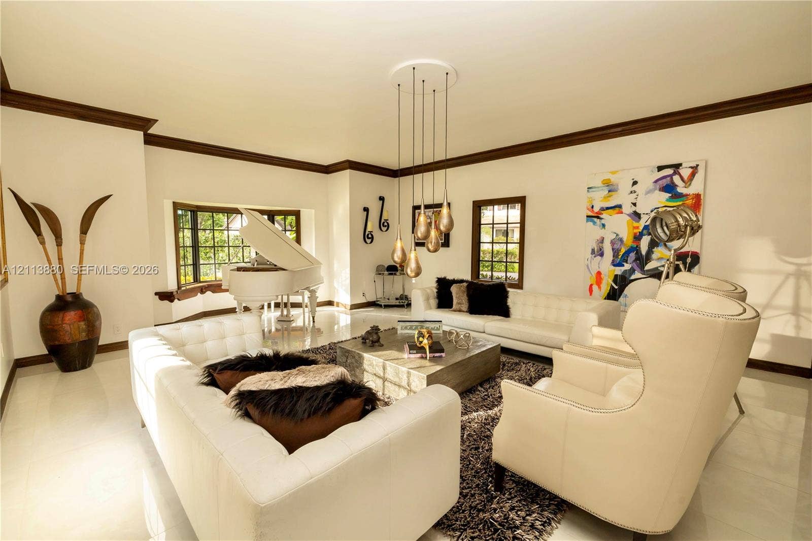 900 Coco Plum Way, Plantation, FL 33324 Living area featuring polished tile flooring, dark crown molding, a bay window, and a multi-pendant light fixture