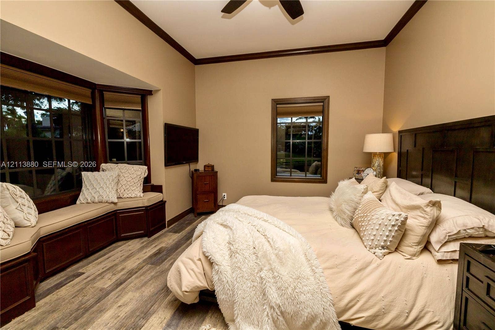 900 Coco Plum Way, Plantation, FL 33324 Bay window with built-in bench seating, wood-finish flooring, dark wood-tone crown molding, and grid-pattern window panes