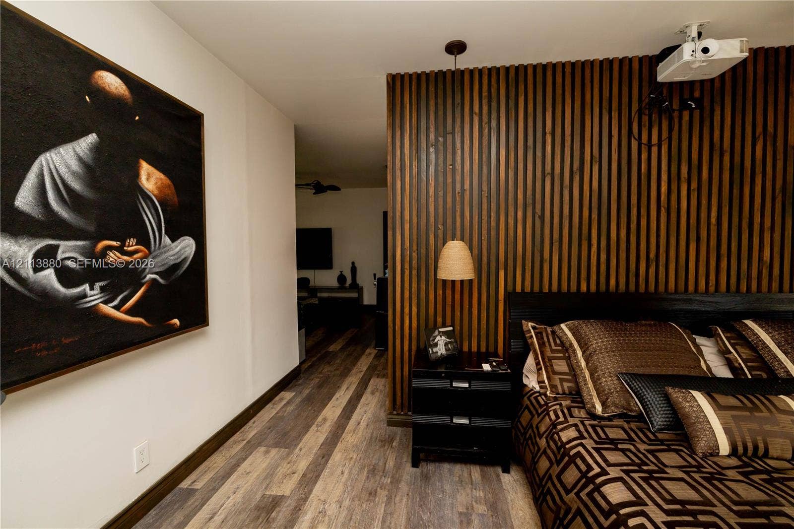 900 Coco Plum Way, Plantation, FL 33324 Vertical wood slat accent wall featuring a hanging pendant light and multi-toned wood-finish flooring