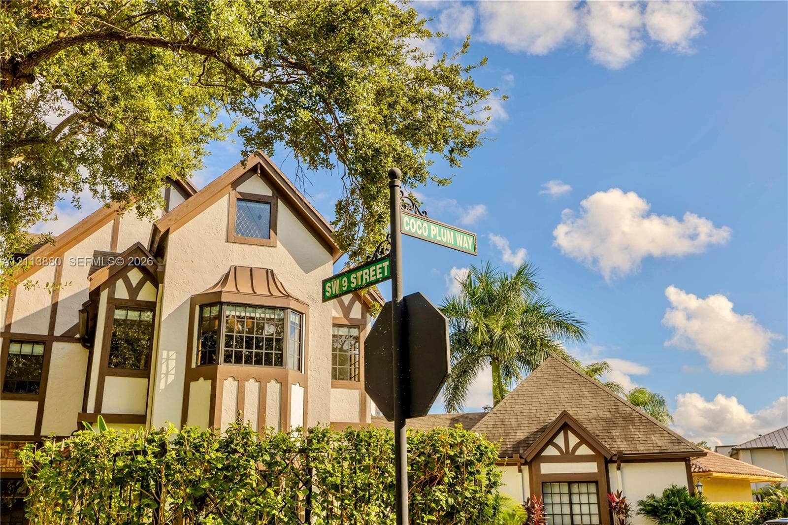 900 Coco Plum Way, Plantation, FL 33324 Tudor-style exterior featuring stucco facade with timber framing, multi-pane bay windows, and mature landscaping
