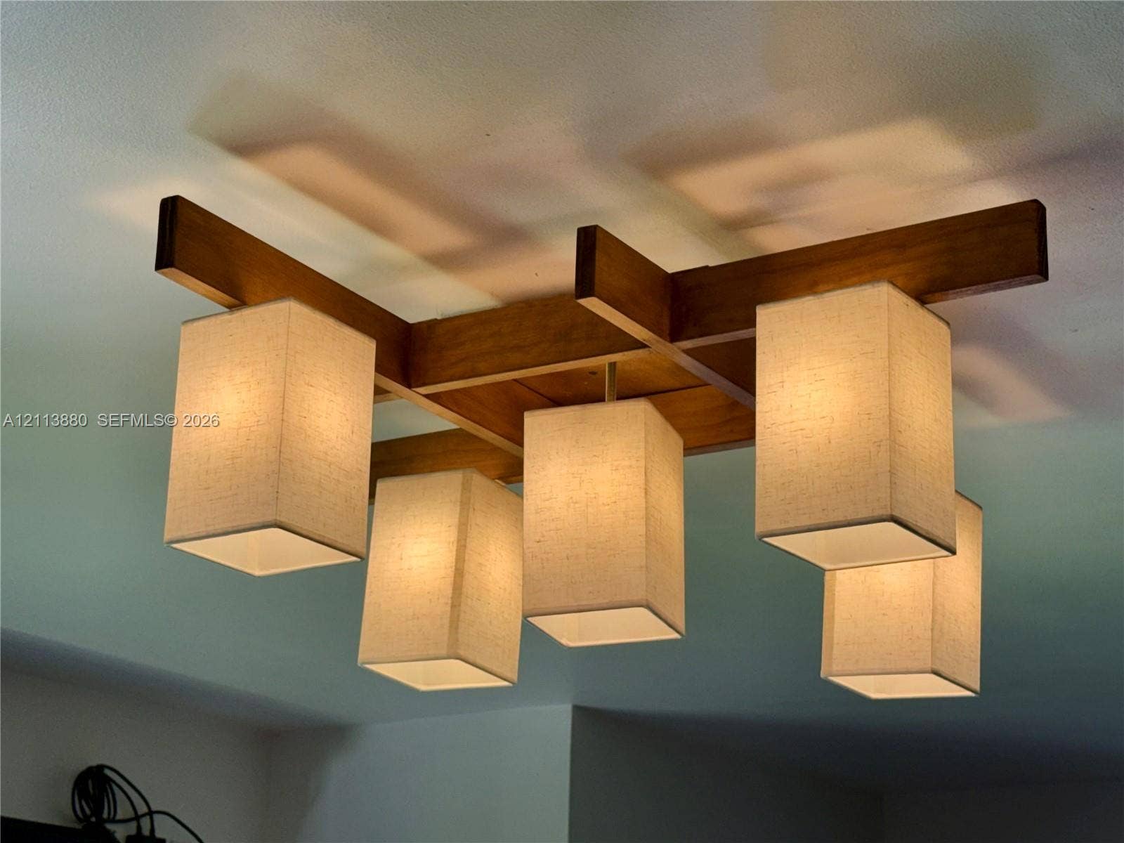 900 Coco Plum Way, Plantation, FL 33324 Flush-mount ceiling fixture featuring a geometric wood-finish frame and five rectangular fabric shades