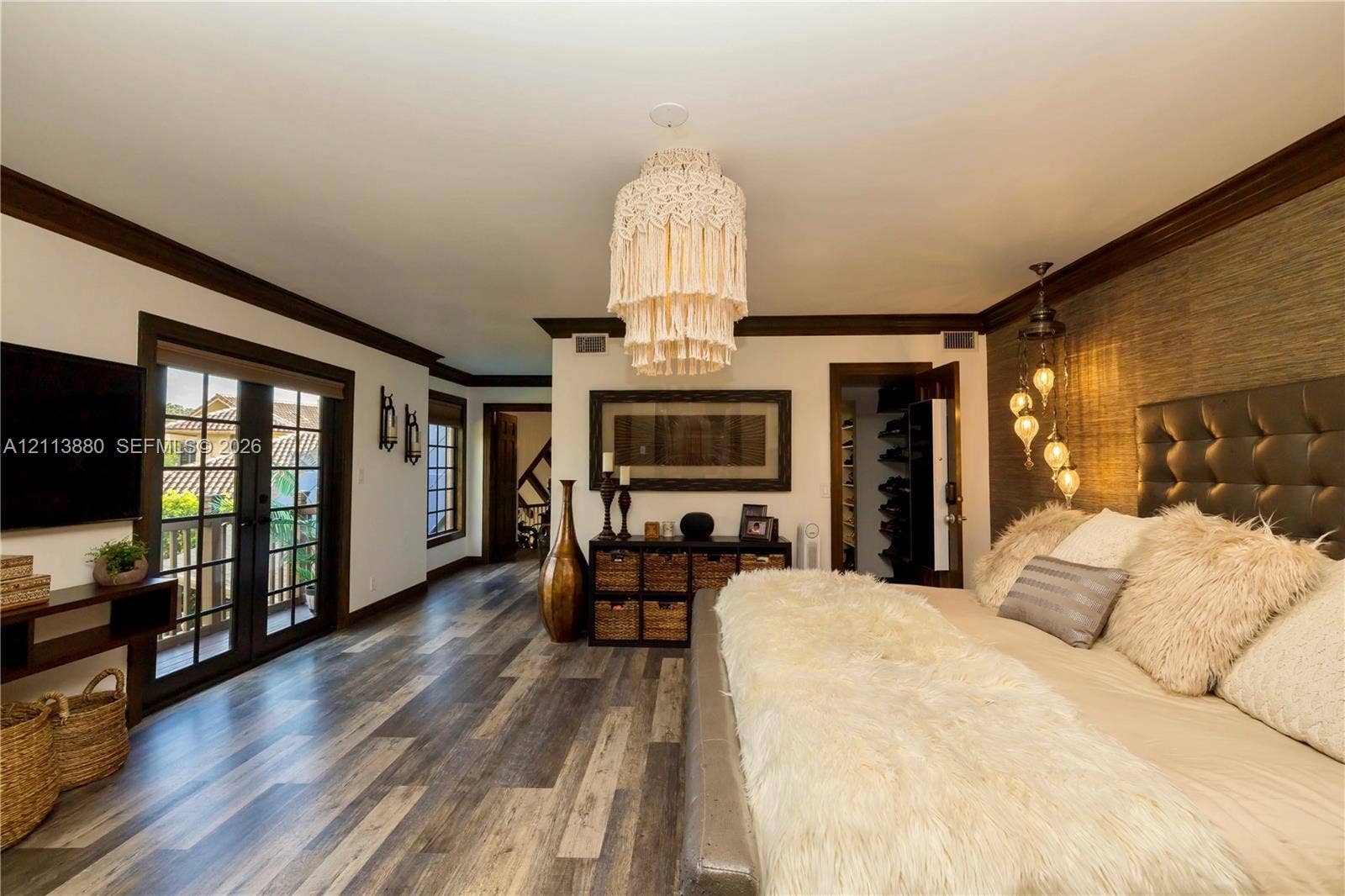 900 Coco Plum Way, Plantation, FL 33324 Wood-finish flooring, dark wood-trimmed doorways and windows, integrated French doors, and a textured accent wall