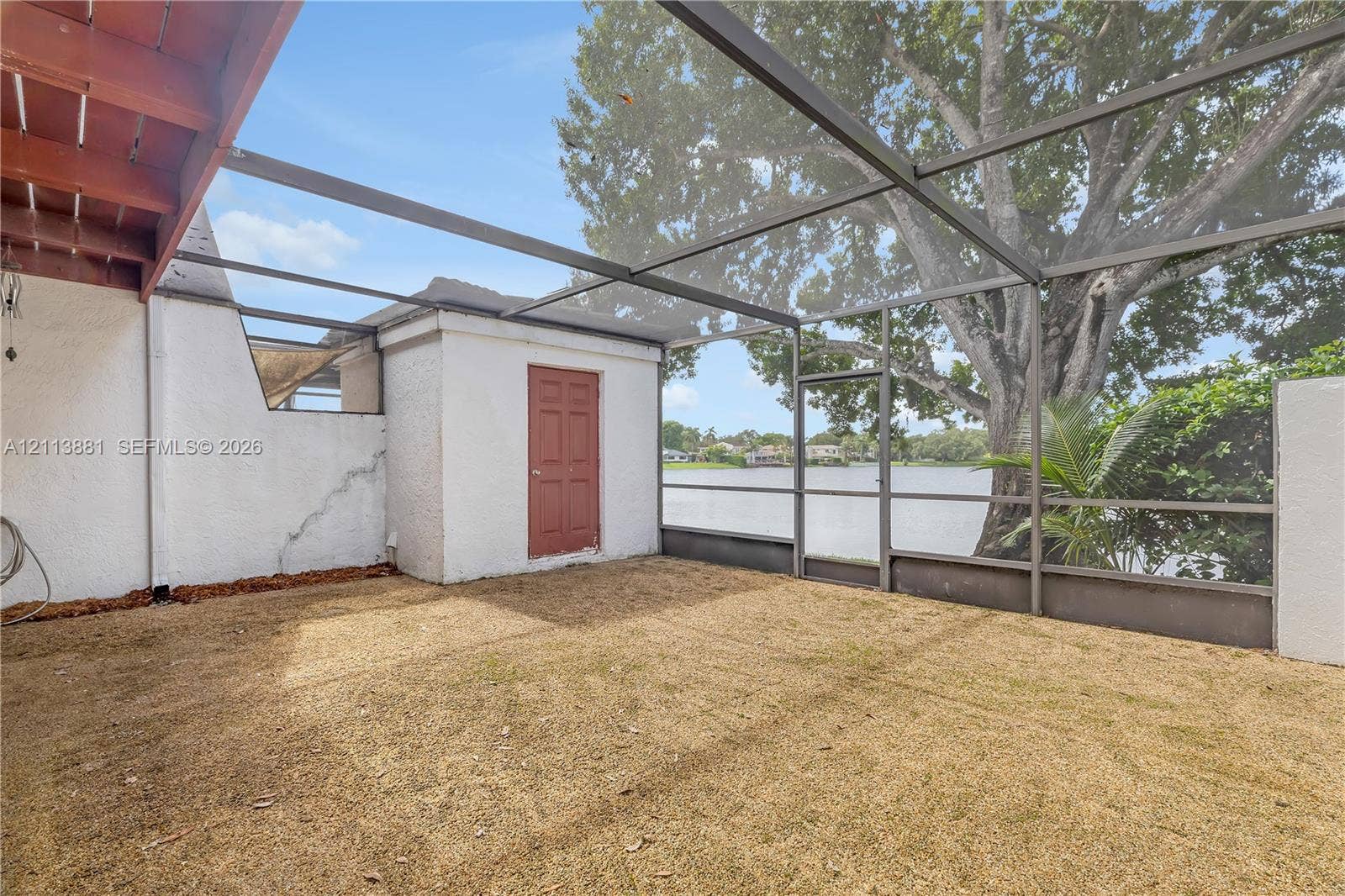 3886 Meadow Lane, #250, Hollywood, FL 33021 Screened-in patio featuring a textured masonry exterior, metal framing, and direct water access