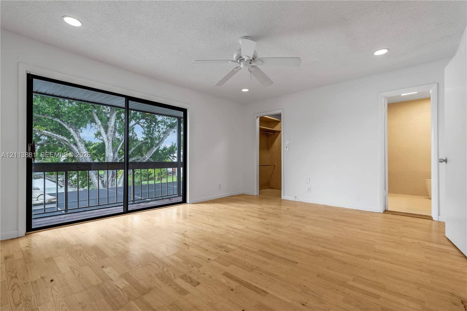 3886 Meadow Lane, #250, Hollywood, FL 33021 Room featuring wood-finish flooring, recessed lighting, a ceiling fan, and black-framed sliding glass doors opening to an exterior balcony