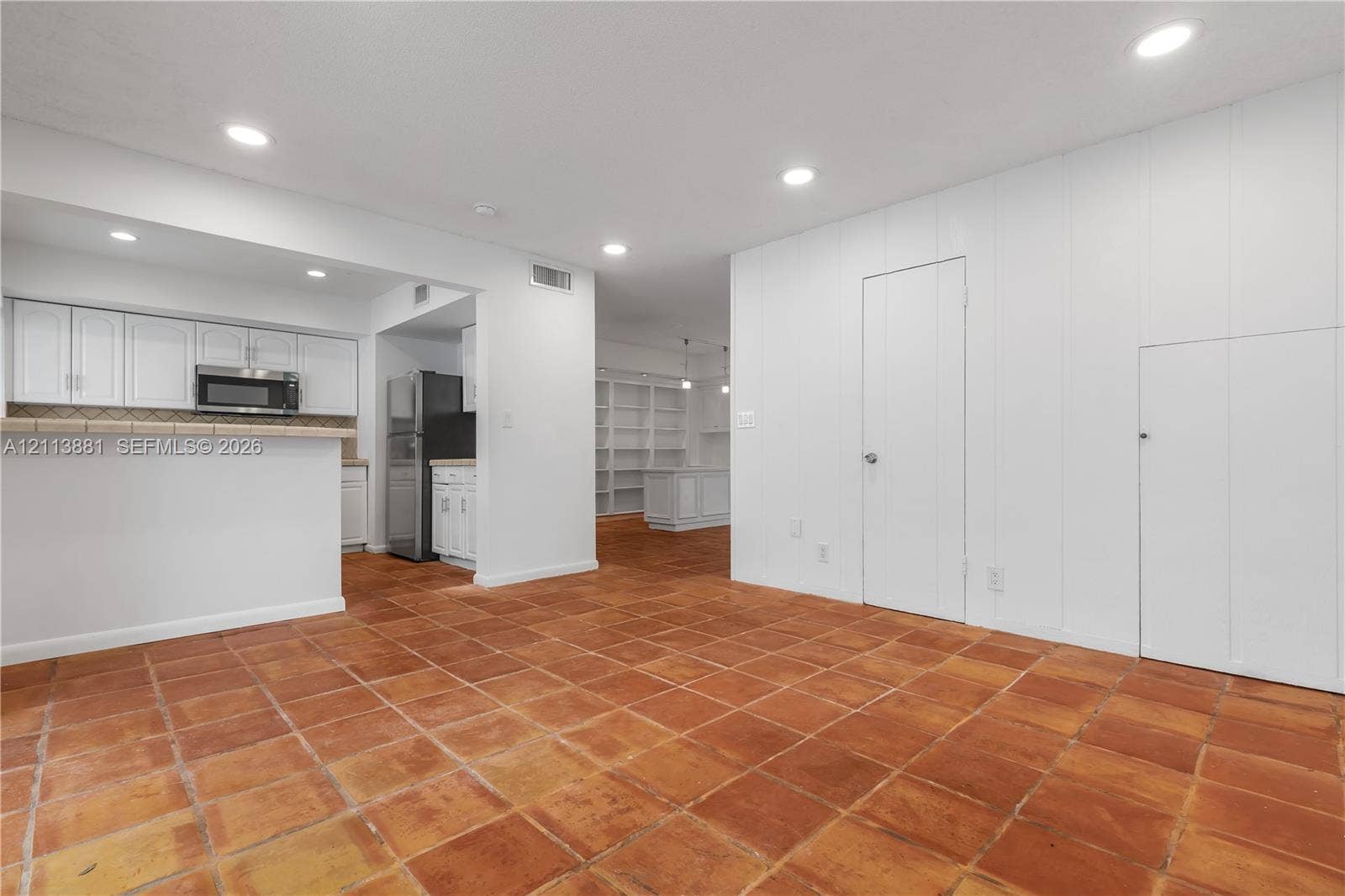 3886 Meadow Lane, #250, Hollywood, FL 33021 Interior space featuring terra-cotta tile flooring, recessed lighting, and built-in white cabinetry with a breakfast bar