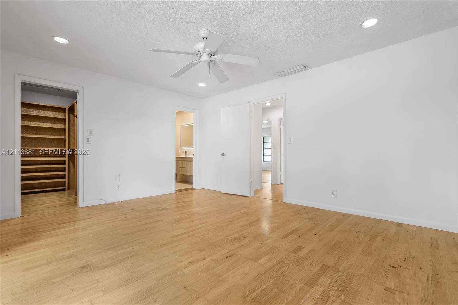 3886 Meadow Lane, #250, Hollywood, FL 33021 Interior room featuring wood-finish flooring, recessed lighting, white ceiling fan, and built-in closet shelving