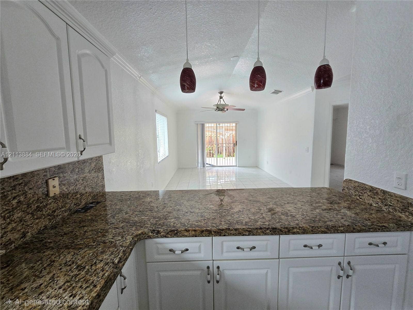 7456 W 34th Court, Hialeah, FL 33018 Kitchen featuring white shaker-style cabinetry, stone-finish countertops, three suspended pendant lights, and tile flooring