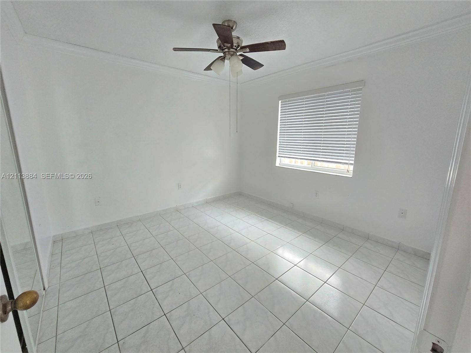 7456 W 34th Court, Hialeah, FL 33018 Neutral-toned tile flooring, ceiling fan with integrated lighting, and horizontal window blinds