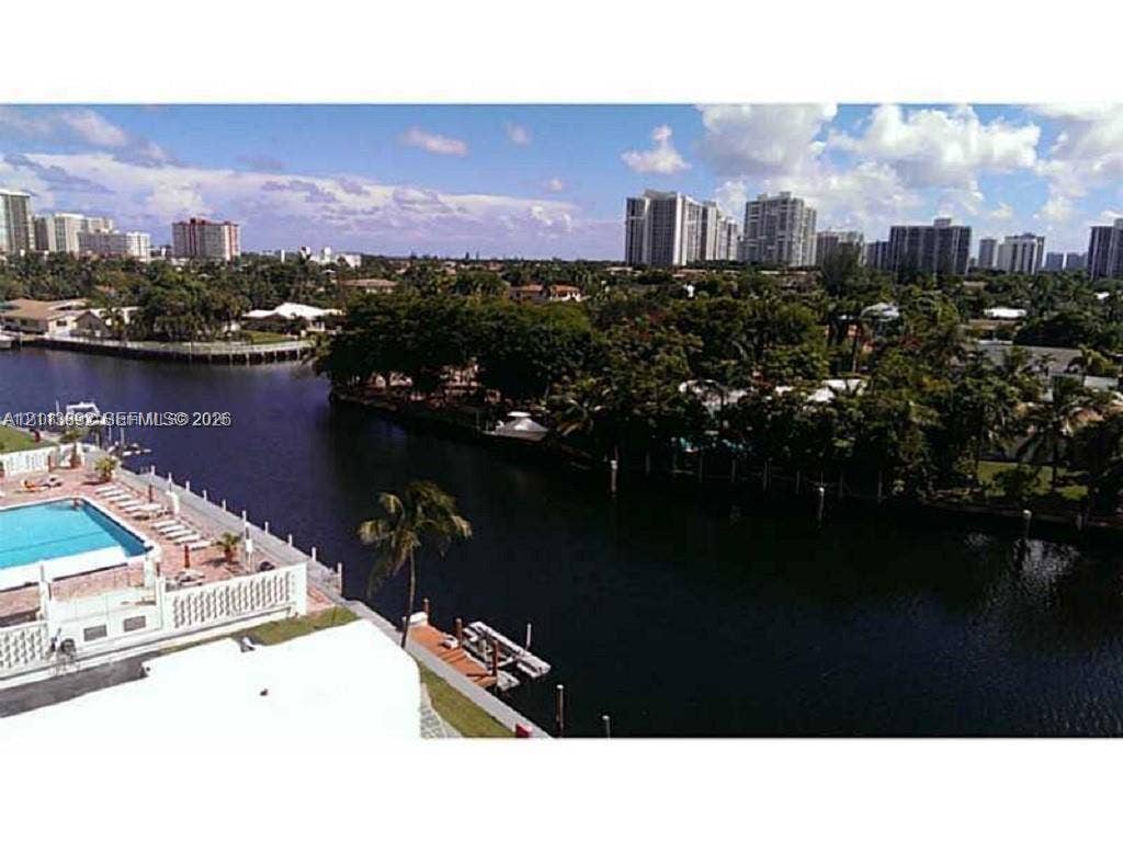 401 Golden Isles Drive, #509, Hallandale Beach, FL 33009 Waterfront exterior featuring a swimming pool, paved pool deck, and private boat dock