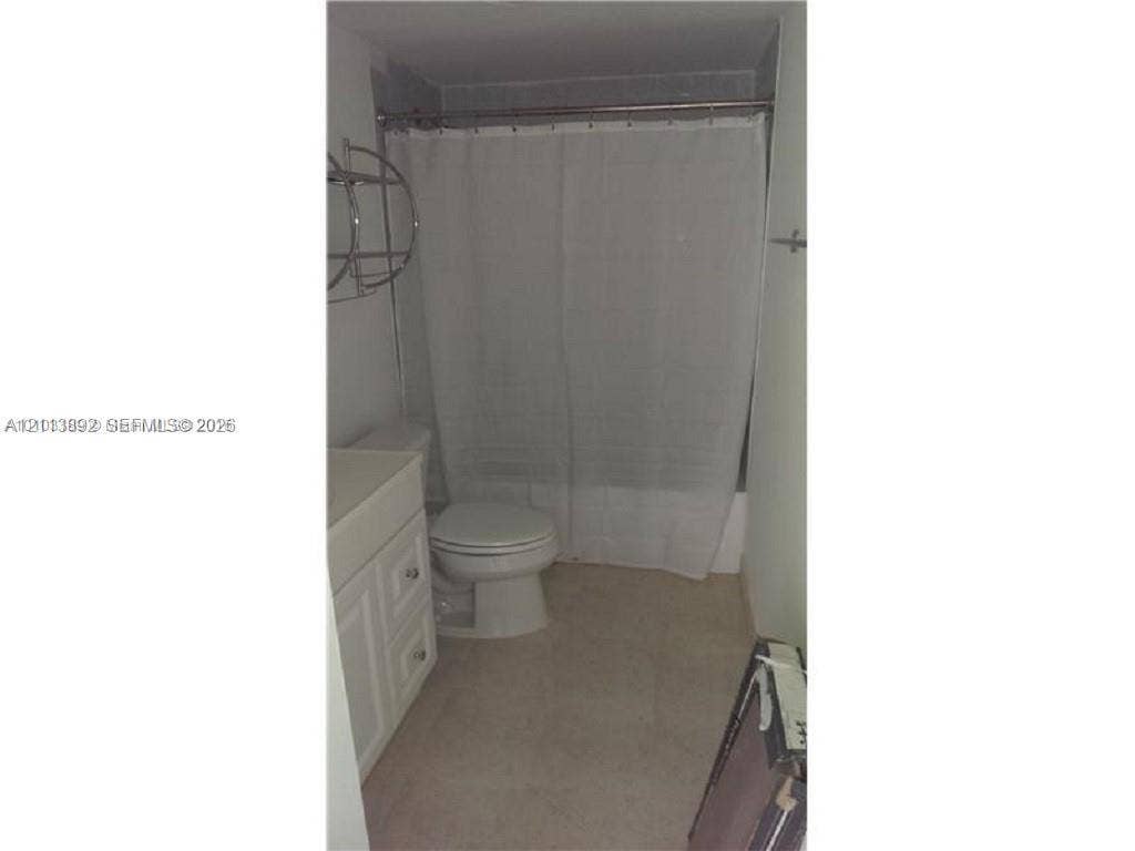401 Golden Isles Drive, #509, Hallandale Beach, FL 33009 Bathroom featuring a white vanity cabinet with drawers, a toilet, and a tub-shower combination with a metal tension rod