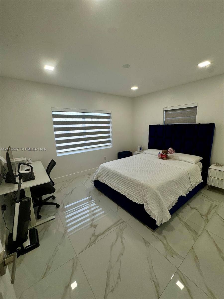 520 E 58th Street, Hialeah, FL 33013 Large-format tile flooring with vein detailing, recessed ceiling lighting, and windows featuring integrated dual-layered roller shades