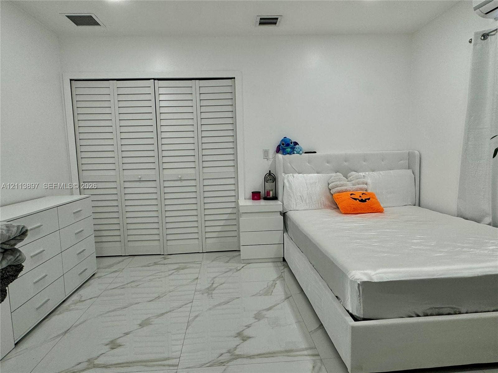 520 E 58th Street, Hialeah, FL 33013 Large-format tile flooring featuring a neutral veined pattern and white louvered-style closet doors