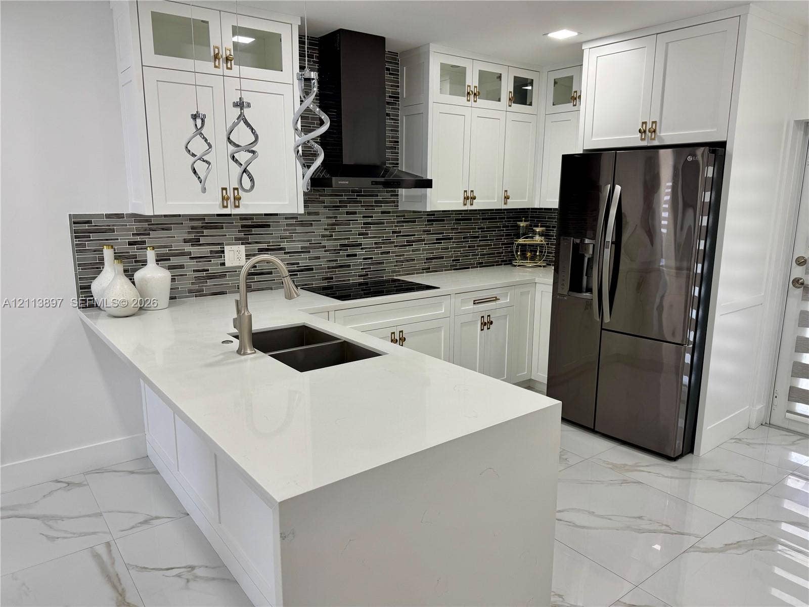 520 E 58th Street, Hialeah, FL 33013 Kitchen featuring white cabinetry, quartz countertops, a mosaic tile backsplash, a stainless steel undermount sink with a gooseneck faucet, and large-format tile flooring