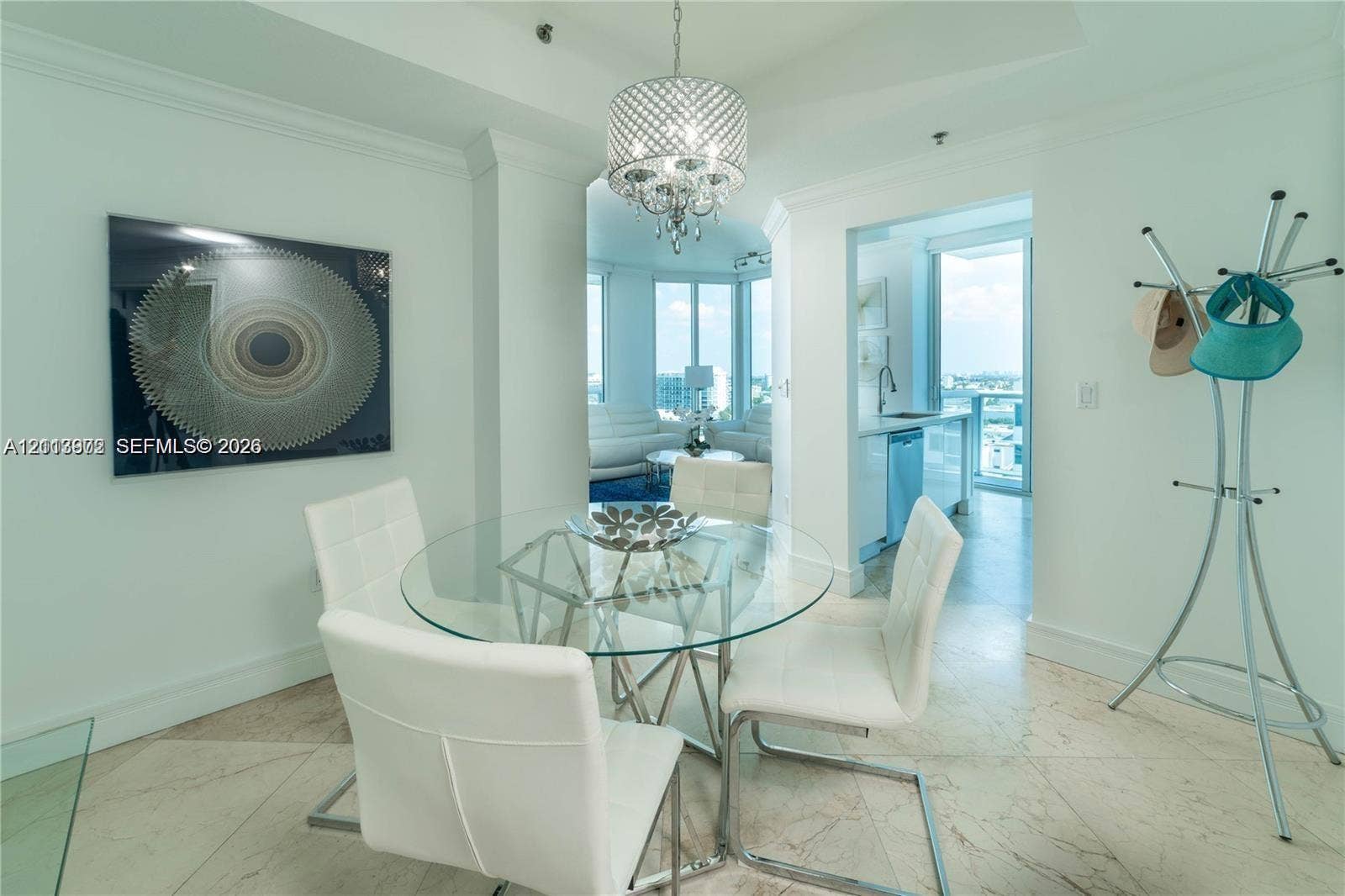 6515 Collins Avenue, #1609, Miami Beach, Miami Beach, FL 33141 Dining area featuring polished stone tile flooring, crown molding, and a tiered crystal chandelier