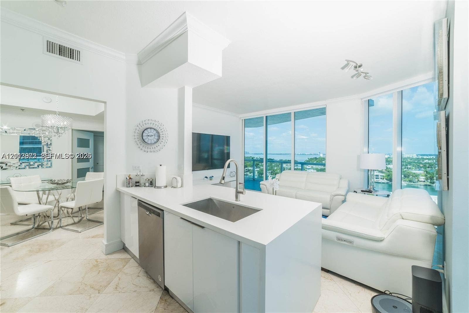6515 Collins Avenue, #1609, Miami Beach, Miami Beach, FL 33141 Kitchen island with stone countertop, stainless steel under-mount sink, integrated stainless steel dishwasher, and floor-to-ceiling windows