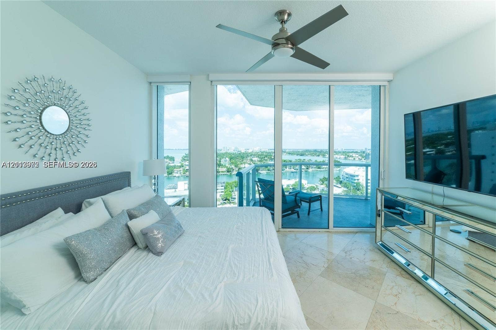 6515 Collins Avenue, #1609, Miami Beach, Miami Beach, FL 33141 Floor-to-ceiling glass sliding doors, polished stone flooring, balcony access, and a ceiling-mounted fan