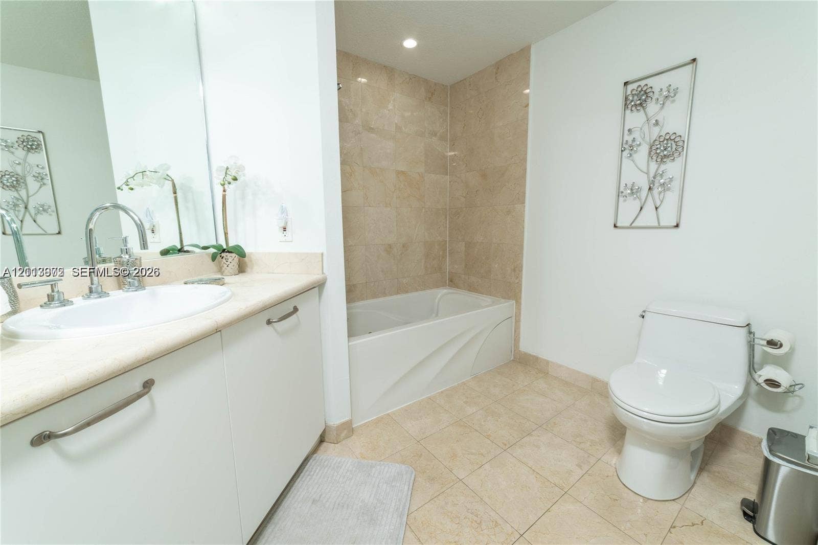 6515 Collins Avenue, #1609, Miami Beach, Miami Beach, FL 33141 Bathroom featuring a vanity with an integrated basin, neutral stone-finish wall tile surrounding the bathtub, and light-toned floor tiling