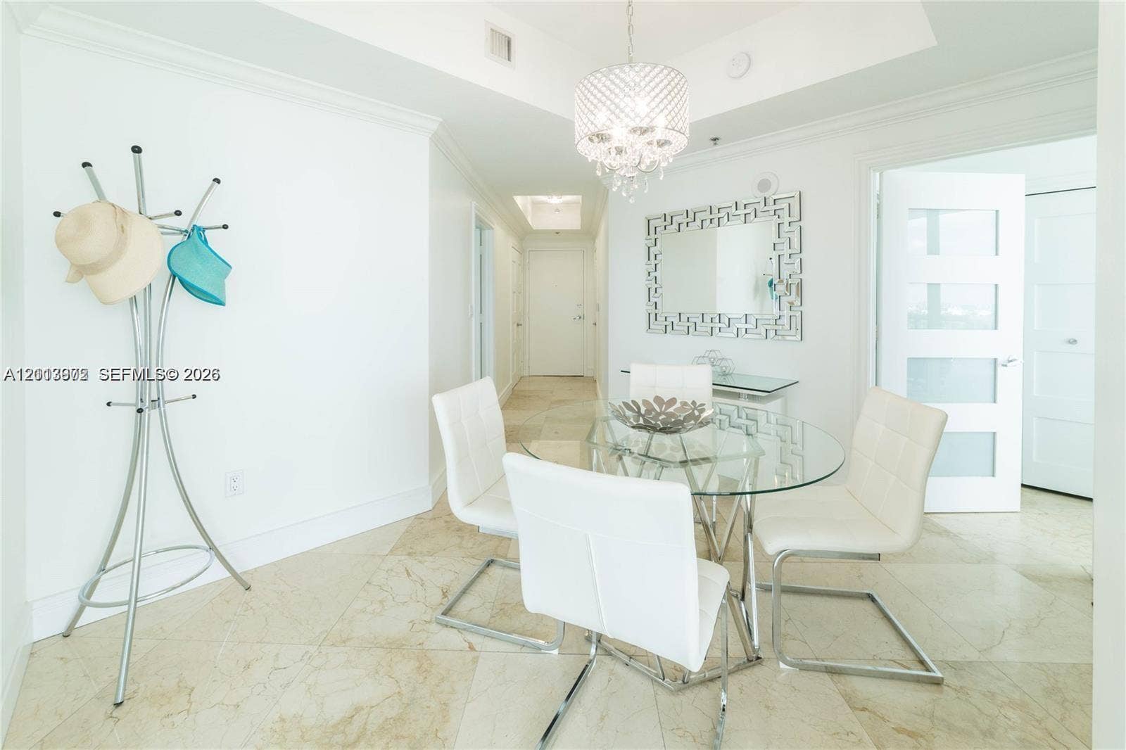 6515 Collins Avenue, #1609, Miami Beach, Miami Beach, FL 33141 Light-toned stone tile flooring throughout, recessed tray ceiling, crystal-style chandelier, and white-framed door with translucent panels