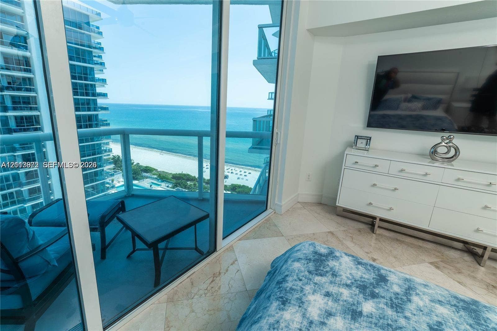 6515 Collins Avenue, #1609, Miami Beach, Miami Beach, FL 33141 Floor-to-ceiling glass walls, private balcony with glass railing, stone flooring, and expansive ocean and shoreline scenery