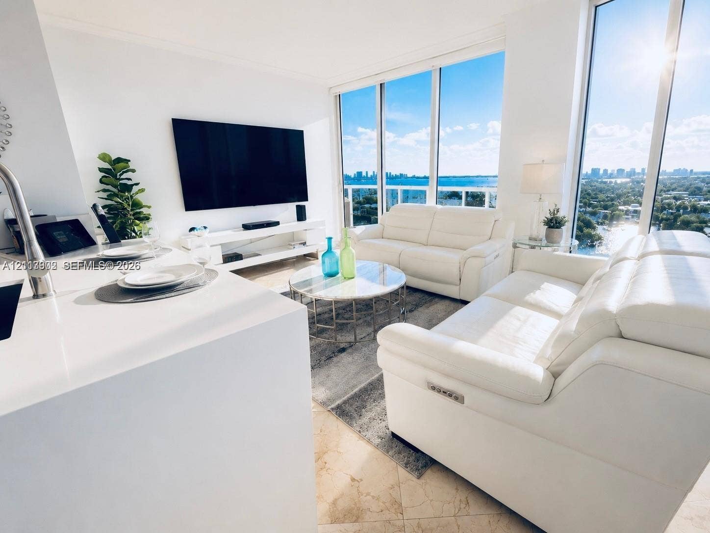 6515 Collins Avenue, #1609, Miami Beach, Miami Beach, FL 33141 Floor-to-ceiling windows, stone-tile flooring, and minimalist solid-surface kitchen island