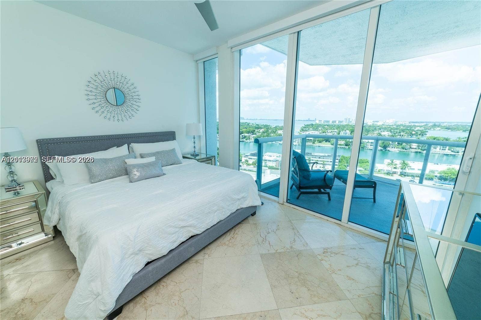6515 Collins Avenue, #1609, Miami Beach, Miami Beach, FL 33141 Floor-to-ceiling sliding glass doors, private balcony with glass railing, large-format stone flooring, and ceiling fan