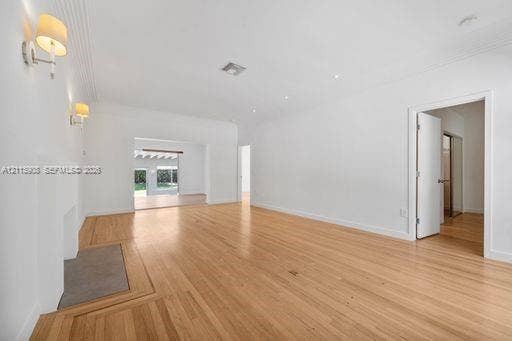Open-concept room featuring light wood-finish flooring, a decorative fireplace, dual wall-mounted sconces, and recessed lighting