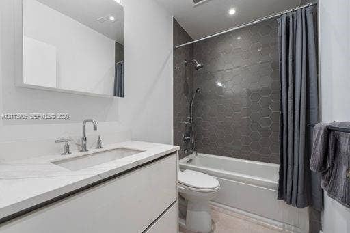 Bathroom featuring a floating vanity with a stone-top integrated sink, chrome widespread faucet, frameless wall-mounted mirror, and a shower-tub combination with dark hexagonal tile surround