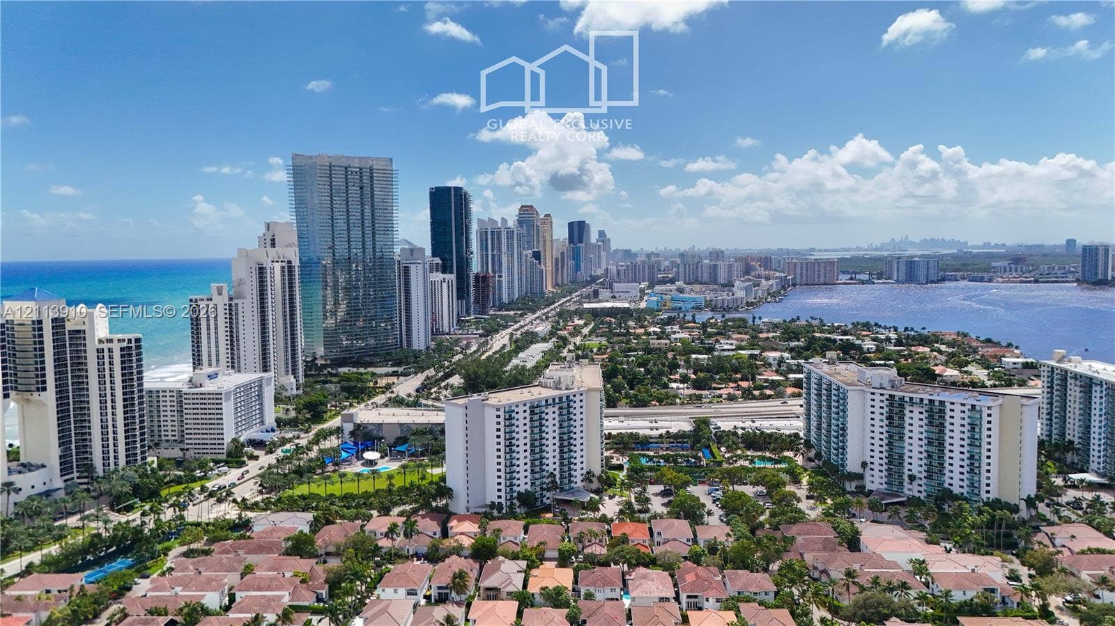19380 Collins Avenue, #218, Sunny Isles Beach, FL 33160 Aerial perspective of a coastal urban landscape featuring ocean and bay shorelines, high-rise buildings, and dense residential development