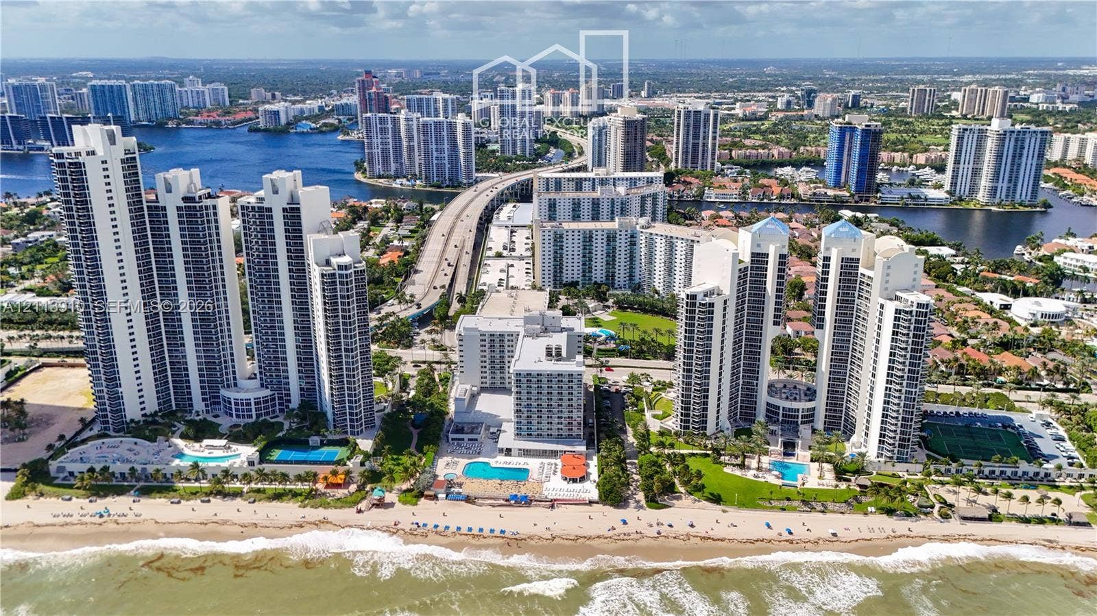 19380 Collins Avenue, #218, Sunny Isles Beach, FL 33160 Aerial perspective of waterfront high-rise residential towers featuring direct beach access, outdoor swimming pools, and tennis courts