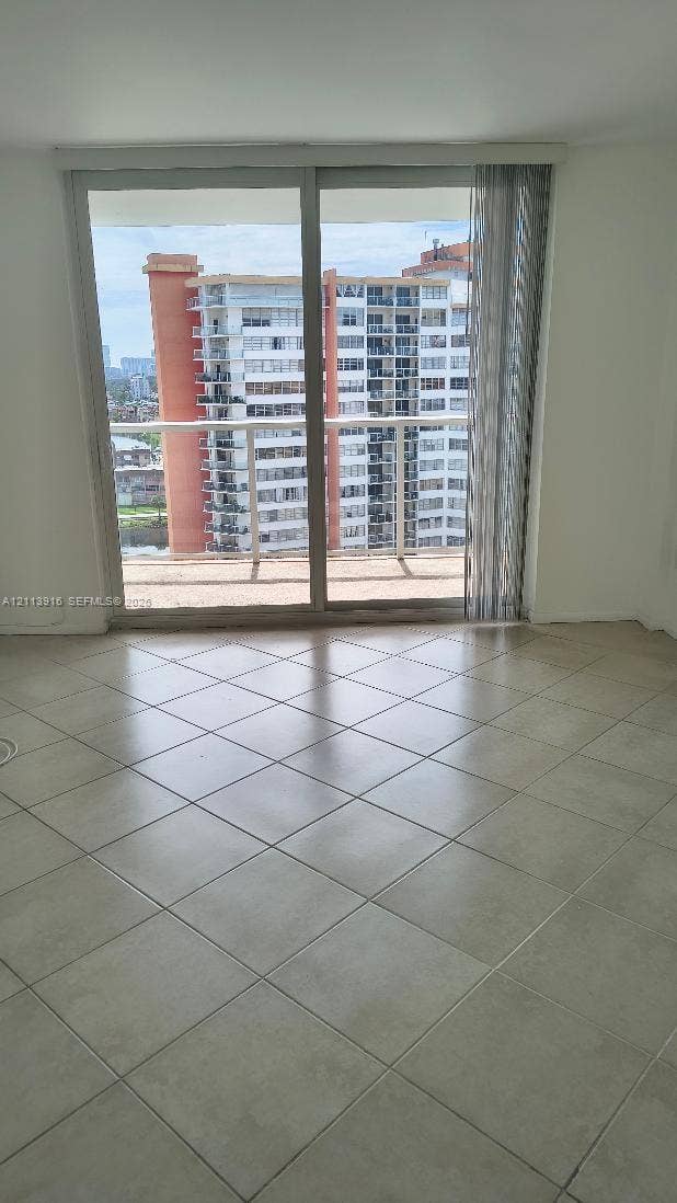 1301 Miami Gardens Drive, #1521 W, Miami, Miami, FL 33179 Large-format tile flooring, floor-to-ceiling sliding glass doors, and a private balcony with horizontal railings