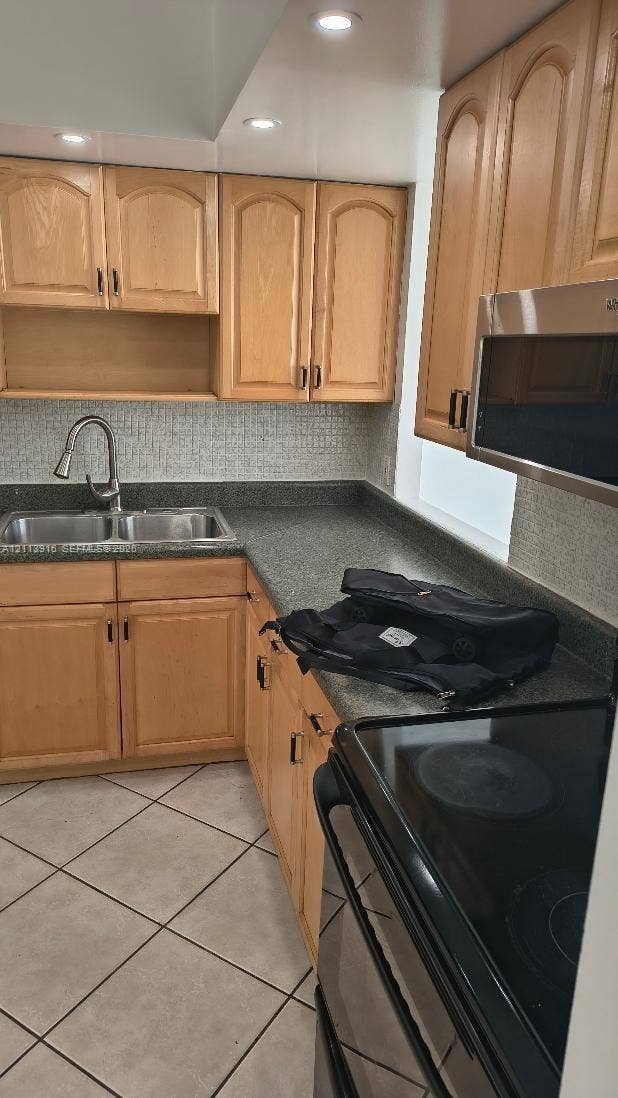 1301 Miami Gardens Drive, #1521 W, Miami, Miami, FL 33179 Kitchen featuring light-finish wood cabinetry, solid-surface countertops, mosaic tile backsplash, double-basin stainless steel sink with pull-down faucet, and ceramic tile flooring