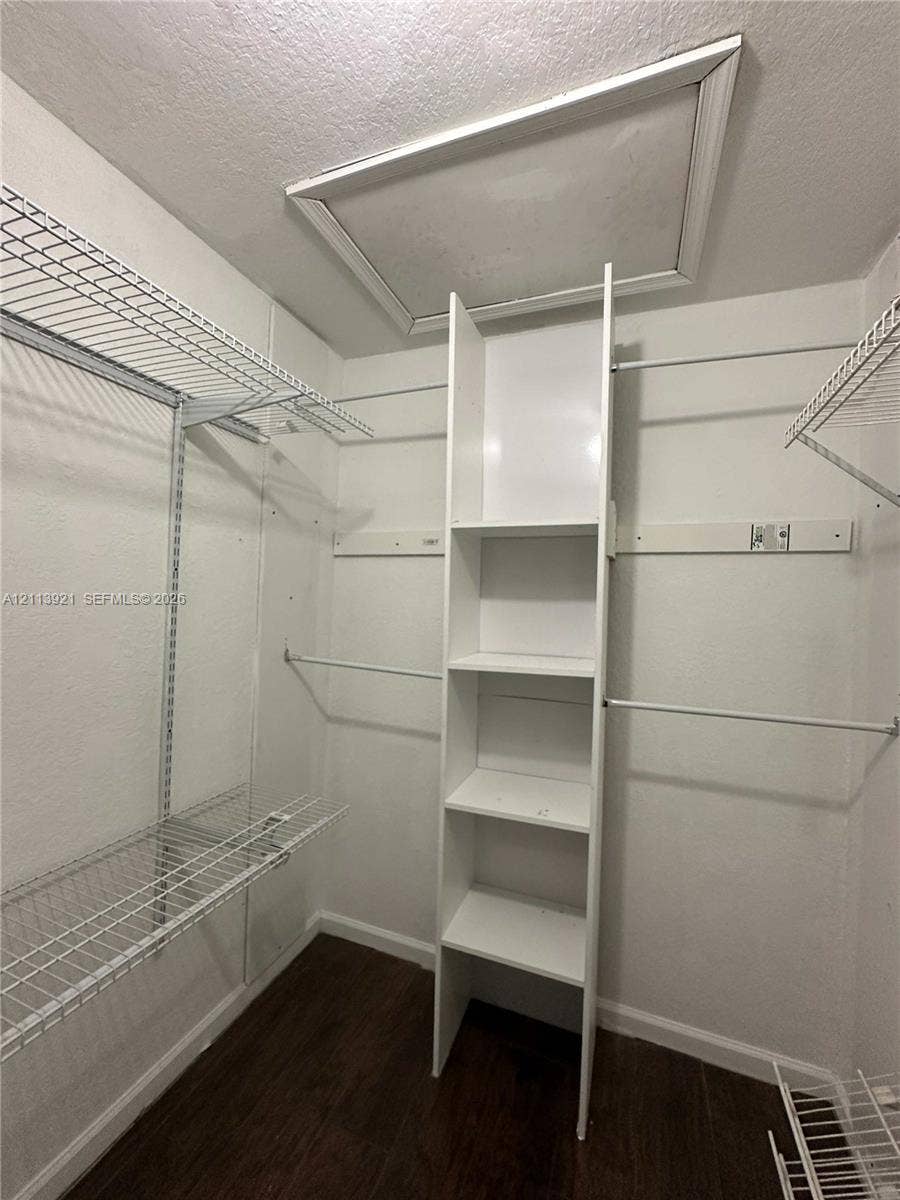 824 Summit Lake Drive, West Palm Beach, West Palm Beach, FL 33406 Closet space featuring white wire shelving, a vertical built-in storage tower with four open shelves, and wood-finish flooring
