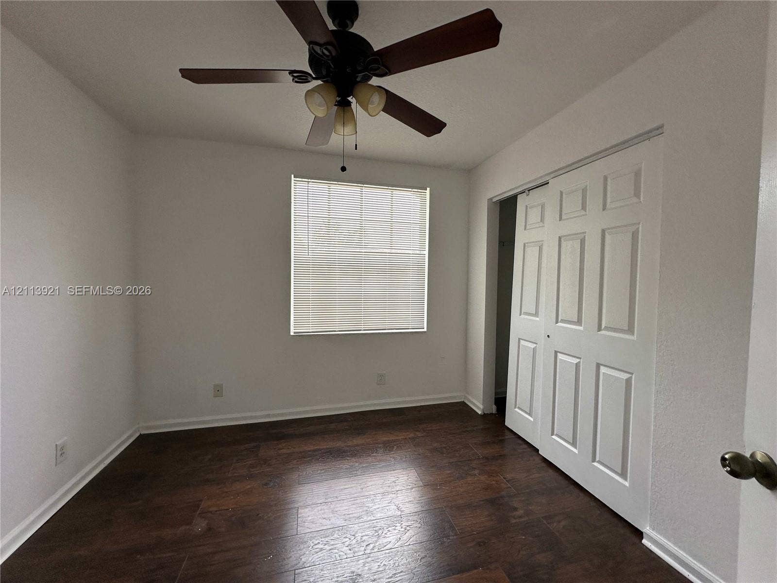 824 Summit Lake Drive, West Palm Beach, West Palm Beach, FL 33406 Wood-finish flooring, central ceiling fan with integrated lighting, multi-pane window, and white paneled sliding closet doors