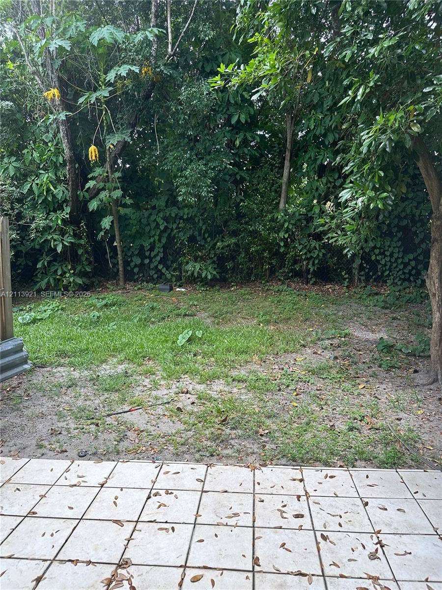 824 Summit Lake Drive, West Palm Beach, West Palm Beach, FL 33406 Outdoor patio featuring square ceramic tile flooring and a perimeter of mature trees and foliage